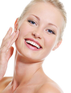 Lady smiling and touching her smooth face, Clear + Brilliant Laser Westchester, Scarsdale NY