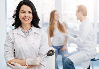 Happy young patient having conversation with dermatologist