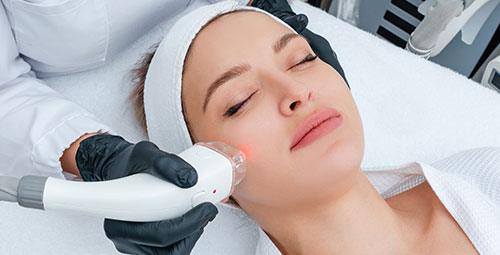 Young woman receiving laser treatment in cosmetology clinic