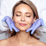 young blonde woman with cosmetologyst hands in a gloves