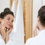 Benefits of Getting a Professional Chemical Peel A person happily examining their clear, rejuvenated skin in a mirror, representing the positive aesthetic benefits of a professional chemical peel.