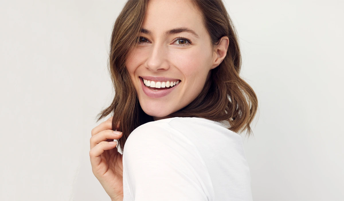 Smooth Results with Dysport A woman laughing and looking back, showcasing the natural-looking and smooth aesthetic results achieved with Dysport.