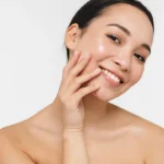 Asian woman posing naked isolated over white wall