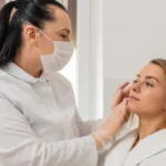 cosmetologist in mask gently inspects facial skin before treatment