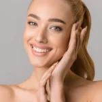 beautiful smiling woman touching her face